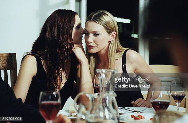 two young women talking at dinner party - whispering stock-fotos und bilder