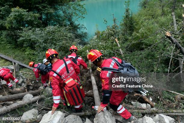 Rescuers climb over a landslide caused by the powerful earthquake on August 10, 2017 in Jiuzhaigou, China. PHOTOGRAPH BY Feature China /