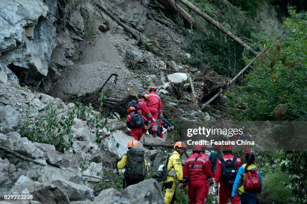 Rescuers climb over a landslide caused by the powerful earthquake on August 10, 2017 in Jiuzhaigou, China. PHOTOGRAPH BY Feature China /