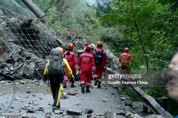 Rescuers climb over a landslide caused by the powerful earthquake on August 10, 2017 in Jiuzhaigou, China. PHOTOGRAPH BY Feature China /