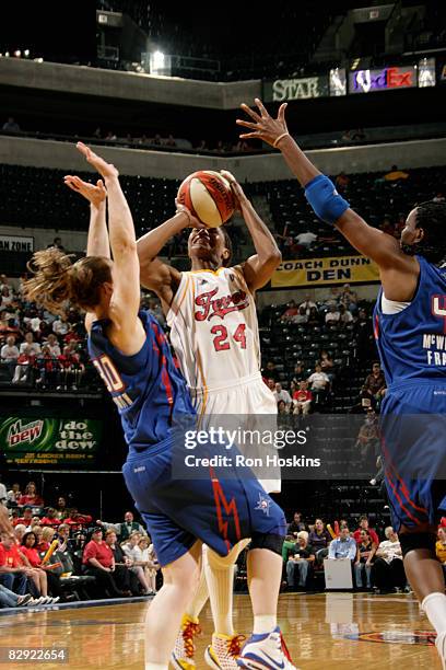 Tamika Catchings of the Indiana Fever battles Katie Smith and Taj McWilliams-Franklin of the Detroit Shock in Game One of the Eastern Conference...