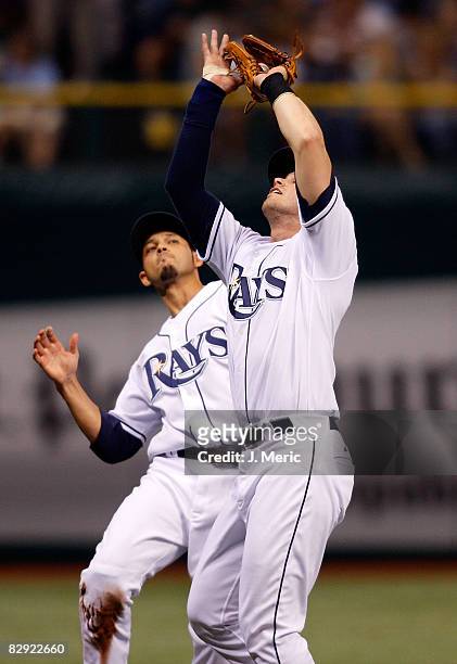 Infielder Evan Longoria of the Tampa Bay Rays catches a foul ball as shortstop Jason Bartlett is there to back him up against the Minnesota Twins...