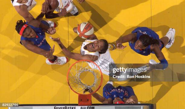 Tamika Catchings of the Indiana Fever battles Taj McWilliams-Franklin and Kara Braxton of the Detroit Shock in Game One of the Eastern Conference...