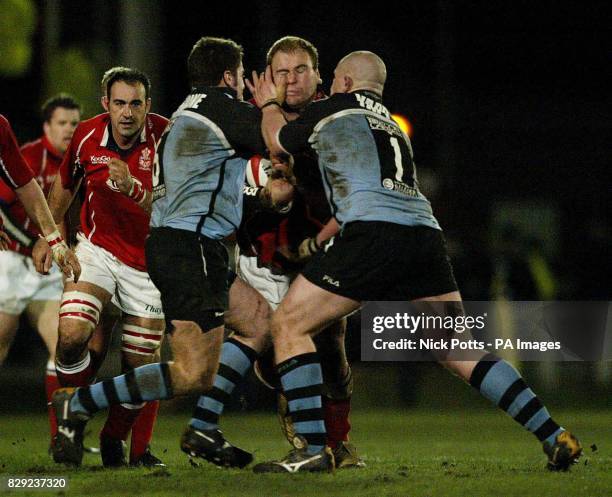 Llanelli's Scott Quinnell is tackled by Cardiff's Dan McShane and John Yapp during Welsh League game at Strady Park. Llanelli defeated Cardiff 39-26.