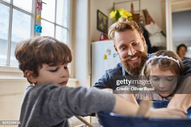 father and children baking at home - hipster in a kitchen stockfoto's en -beelden