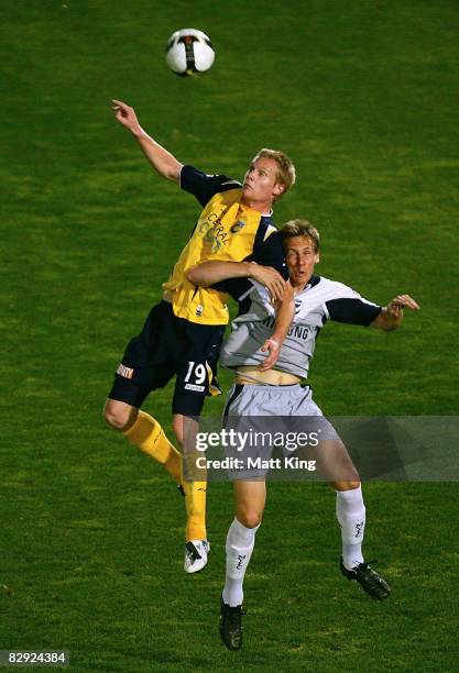 Matt Simon of the Mariners and Michael Thwaite of the Victory collide while going for a header during the round five A-League match between the...