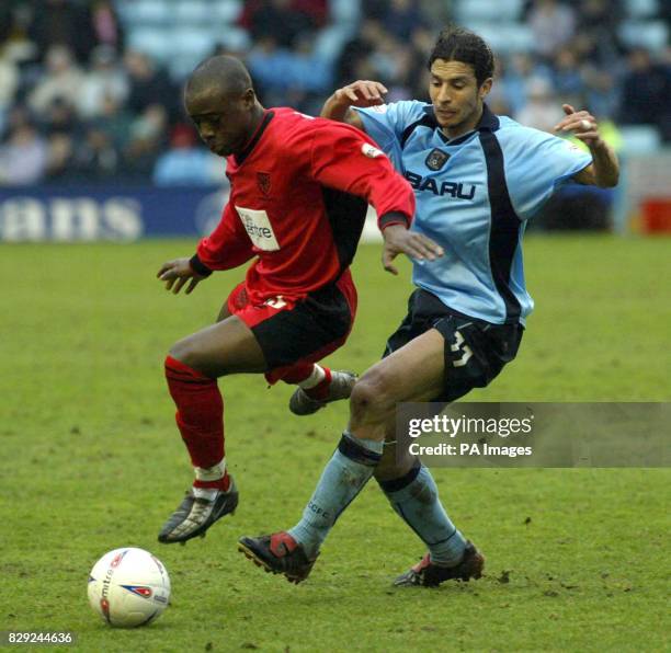 Damien Francis of Wimbledon evades the challenge from Youssef Chippo of Coventry City , during the Nationwide Division One match at The Highfield...