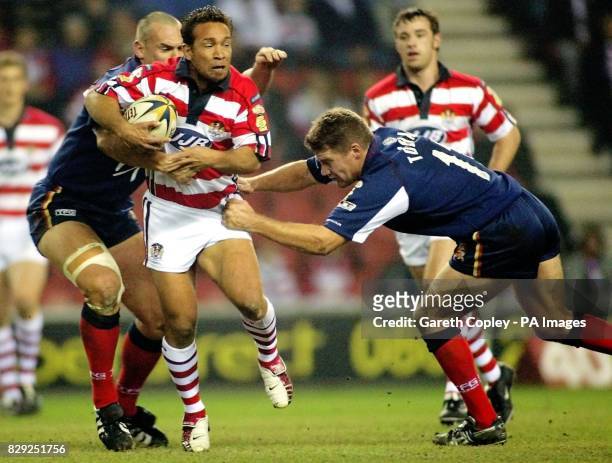 Wigan's Adrian Lam is tackled by London's Francis Stephenson and Matt Toshack during their Tetley Bitter Super League game at the JJB Stadium, Wigan.