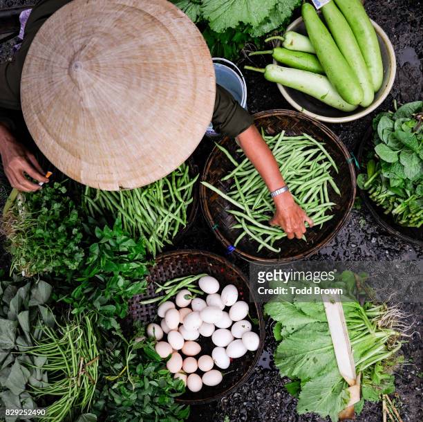 vietnamese woman at market with vegetables from above - vietnam market stock pictures, royalty-free photos & images