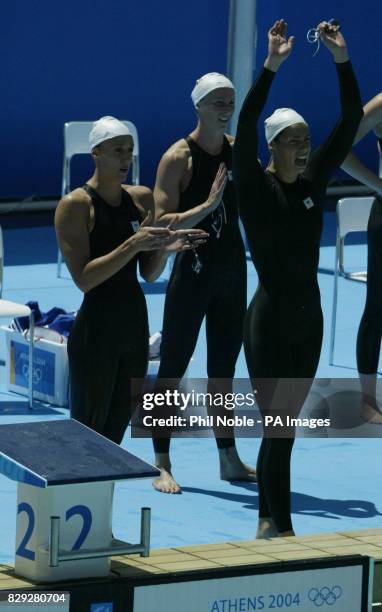 British swimmers Karen Pickering, Alison Sheppard and Kathryn Evans react as team mate Melanie Marshall finishes their heat in the Women's 4x100m...