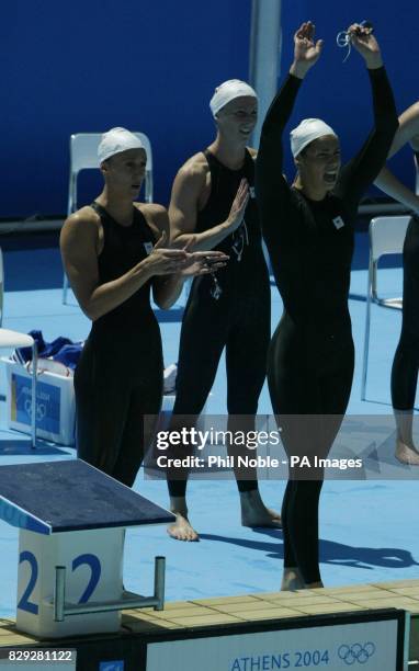 British swimmers Karen Pickering, Alison Sheppard and Kathryn Evans react as team mate Melanie Marshall finishes their heat in the Women's 4x100m...