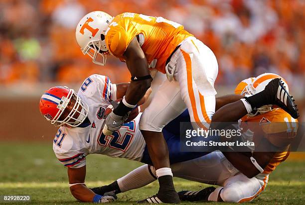 Emmanuel Moody of the Florida Gators is tackled by teammates DeAngelo Willingham and Eric Berry of the Tennessee Volunteers during their game at...