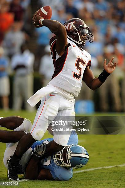 Quarterback Tyrod Taylor of Virginia Tech gets a pass off despite being pressured by defensive end Robert Quinn of North Carolina in the third...