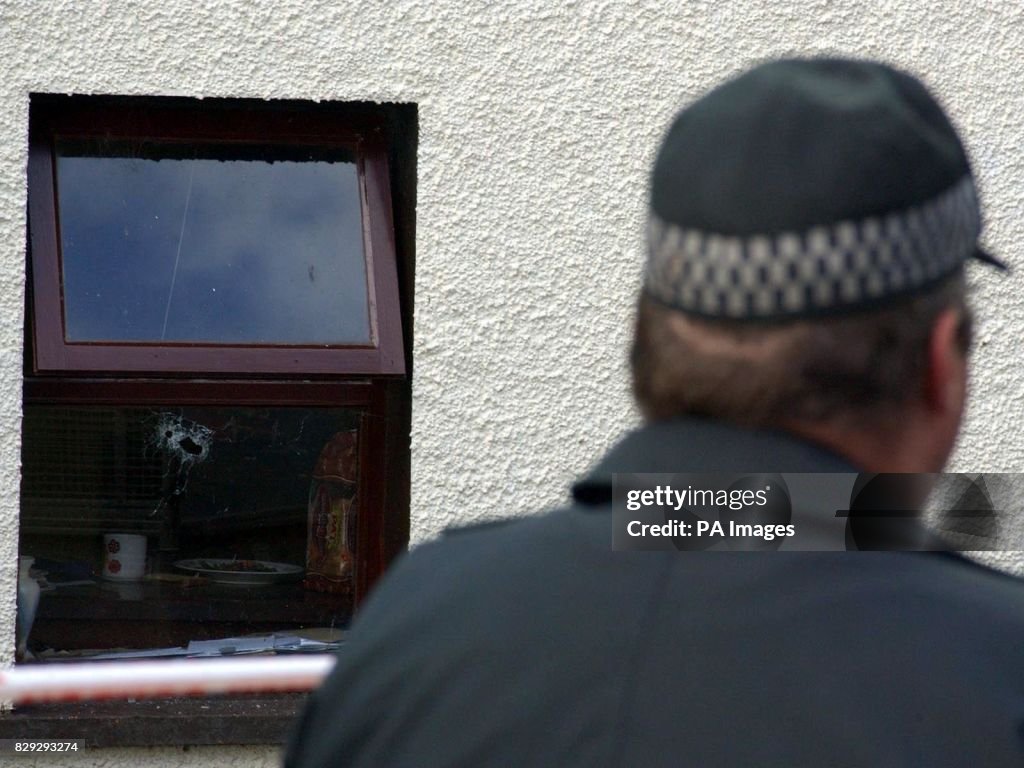 Patrick Devine Files A police officer stands watch at the isolated cottage, outside Claudy ...