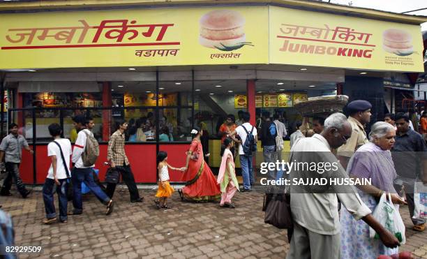 Phil Hazlewood Indian pedestrians walk past a Jumbo King food outlet in Mumbai on September 20, 2008. Dheeraj Gupta is a man with a big vision: to...