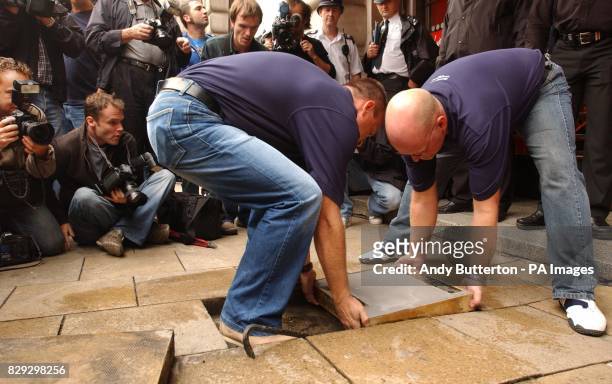 Workmen lay down a slab of concrete for Led Zeppelin guitarist Jimmy Page outside the Virgin Megastore, Piccadilly, central London, to become the...