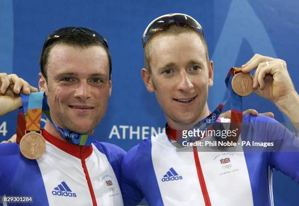 Great Britain's treble medal winner Bradley Wiggins celebrates with team mate Rob Hayles following a third place bronze medal finish in the Track...