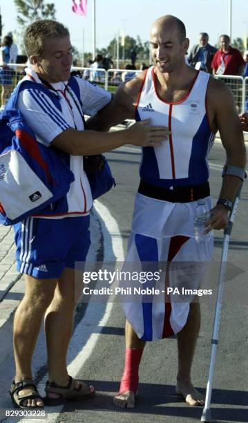 Great Britain's Ian Wynne from Tonbridge is helped by an unidentified Team GB assistant after winning a bronze medal in the Kayak Flatwater Racing K1...