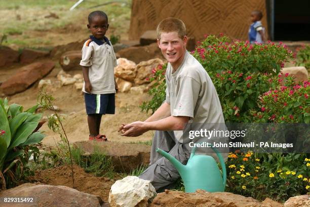 Prince Harry with young orphan Mutsu Potsane at the Mants'ase Children's Home for children orphaned by and suffering from Aids near Mohale's Hoek,...