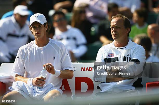 Andy Murray of Great Britain sits down at the change of ends beside captain John Lloyd during his match against Jurgen Melzer of Austria during day...