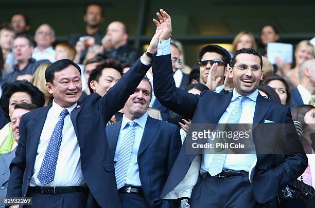 Outgoing Manchester City Chairman and Honorary Club President Thaksin Shinawatra holds aloft the arm of Chairman Designate of Manchester City...