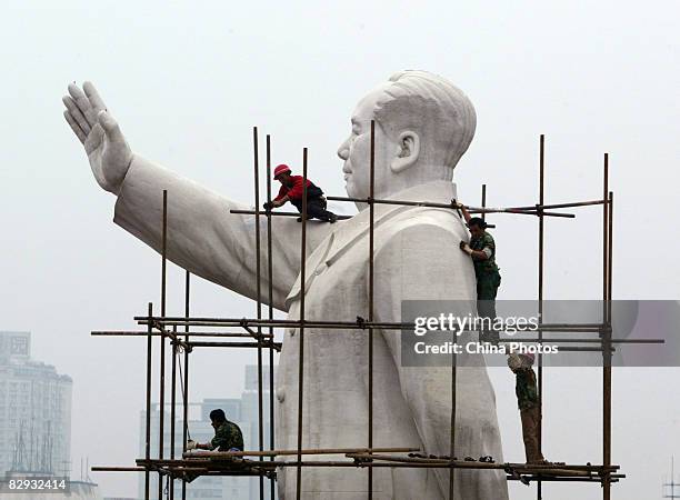 Workers build a scaffold to clean the statue of former Chinese leader Mao Zedong to prepare for the upcoming National Day Holiday September 21, 2008...