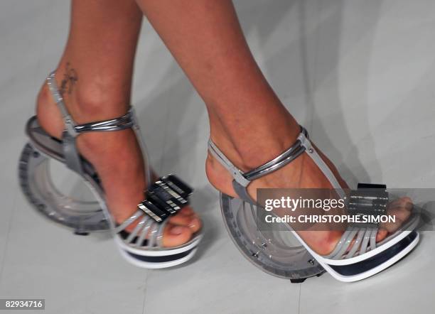 Model presents a pair of shoes by for Gianfranco Ferre fashion house, showcasing the first collections of two young designers, Tommaso Aquilano and...