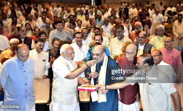 Narendra Modi felicitates BJP President Amit Shah before the start of Parliamentary Meeting during the Monsoon Session at Parliament on August 10,...