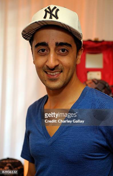 Actor Amir Talai poses with the New Era Cap display during the HBO Luxury Lounge in honor of the 60th annual Primetime Emmy Awards featuring the In...