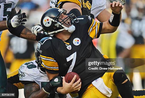 Quarterback Ben Roethlisberger of the Pittsburgh Steelers gets pulled down by his facemask by defensive end Trent Cole of the Philadelphia Eagles on...