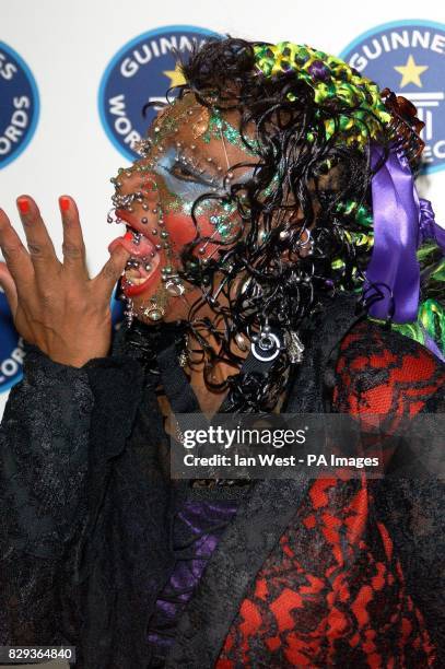 Elaine Davidson, the world's most pierced woman, pokes her finger through her tongue during a photocall for the 50th anniversary party of the...
