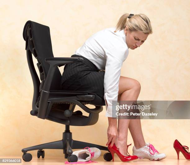 businesswoman changing in to uncomfortable heels to look smart in the office - bunion stock-fotos und bilder