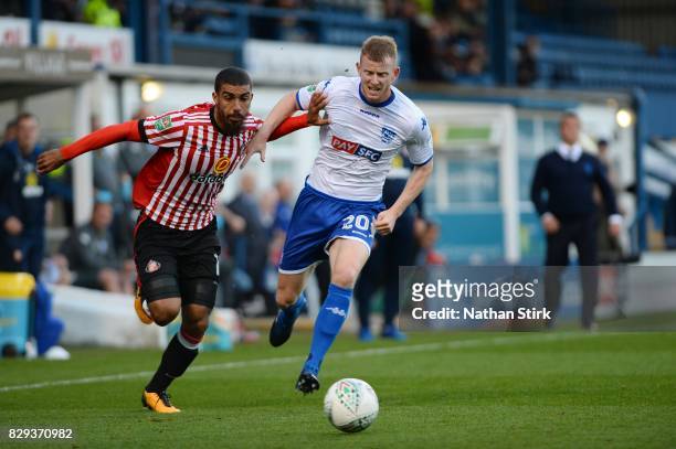 Lewis Grabban of Sunderland and Alex Whitmore of Bury in action during the Carabao Cup First Round match between Bury and Sunderland at Gigg Lane on...