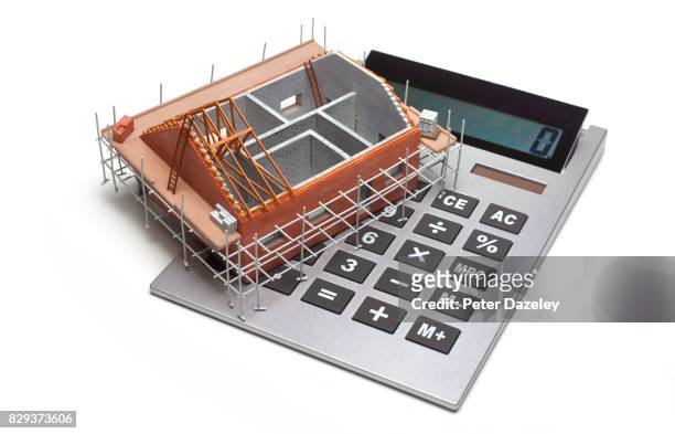 home house under construction with calculator - residential construction ahead of housing starts figures stock-fotos und bilder