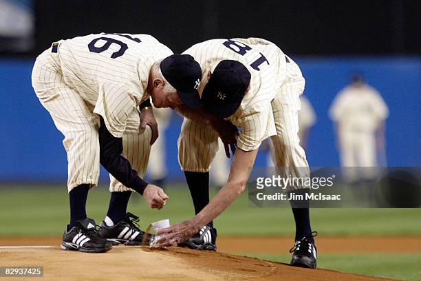 Whitey Ford and Don Larsen scoop up dirt from the mound during a pregame ceremony prior to the start of the last regular season game at Yankee...
