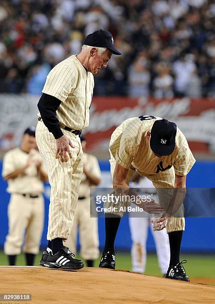 Whitey Ford and Don Larsen scoop up dirt from the mound during a pregame ceremony prior to the start of the last regular season game at Yankee...