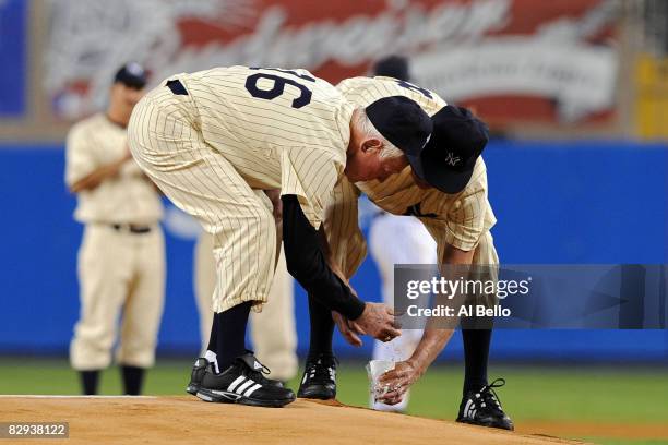 Whitey Ford and Don Larsen scoop up dirt from the mound during a pregame ceremony prior to the start of the last regular season game at Yankee...