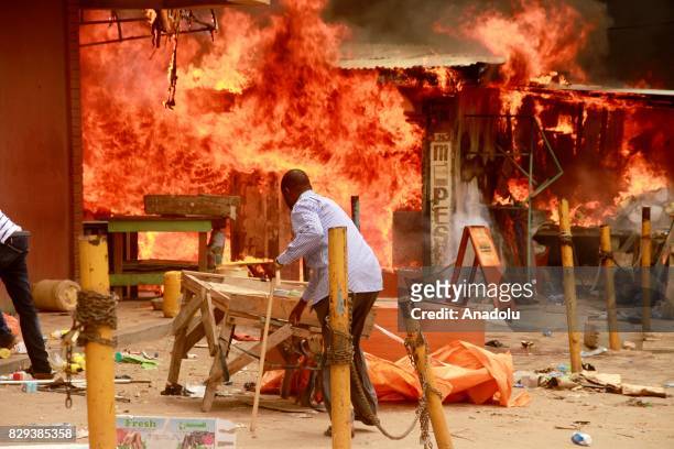 Supporters of the opposition candidate Raila Odinga set shops fire during a demonstration against the election results in Garissa, Kenya on August...
