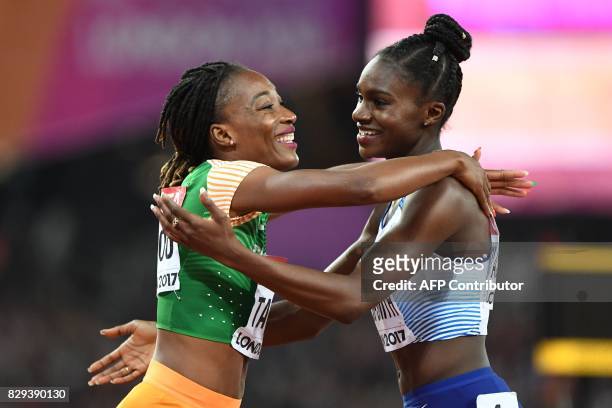Ivory Coast's Marie-Josée Ta Lou celebrates with Britain's Dina Asher-Smith after competing in the semi-final of the women's 200m athletics event at...