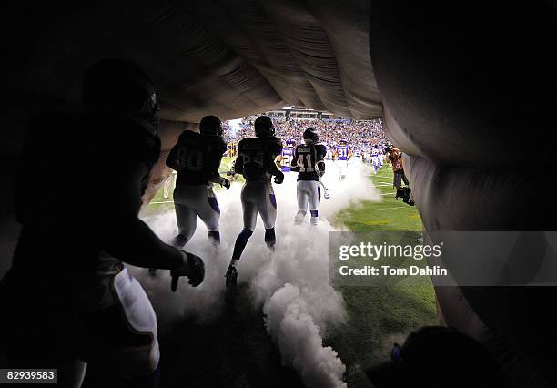 Minnesota Vikings players run from the tunnel onto the field prior to an NFL game against the Carolina Panthers at the Hubert H. Humphrey Metrodome,...