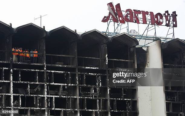 Pakistani rescue workers stand among the wreckage of the devastated Marriott Hotel in Islamabad on September 22, 2008 two days after a suicide truck...