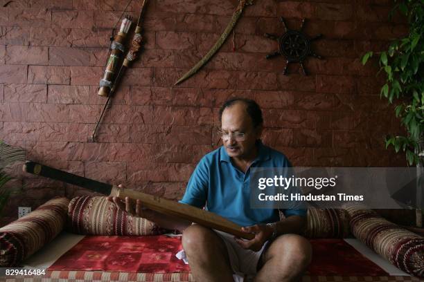 Ajit Wadekar examines his 1960s bat at his home in Worli