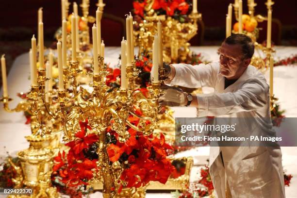 Chief French polisher at Windsor Castle, Eddie Mills, adds candles and a priceless silver-gilt dining plate commissioned by George IV to the centre...