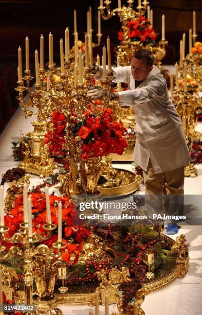 Chief French polisher at Windsor Castle, Eddie Mills, adds candles and a priceless silver-gilt dining plate commissioned by George IV to the centre...