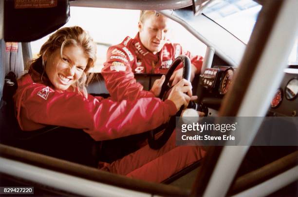 Driver Dale Earnhardt Jr. And model Marisa Miller are photographed riding in his race car for Sports Illustrated in July 2002 in Daytona Beach,...