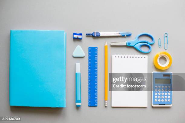 blaue schulmaterial auf grauem hintergrund - stationary stock-fotos und bilder