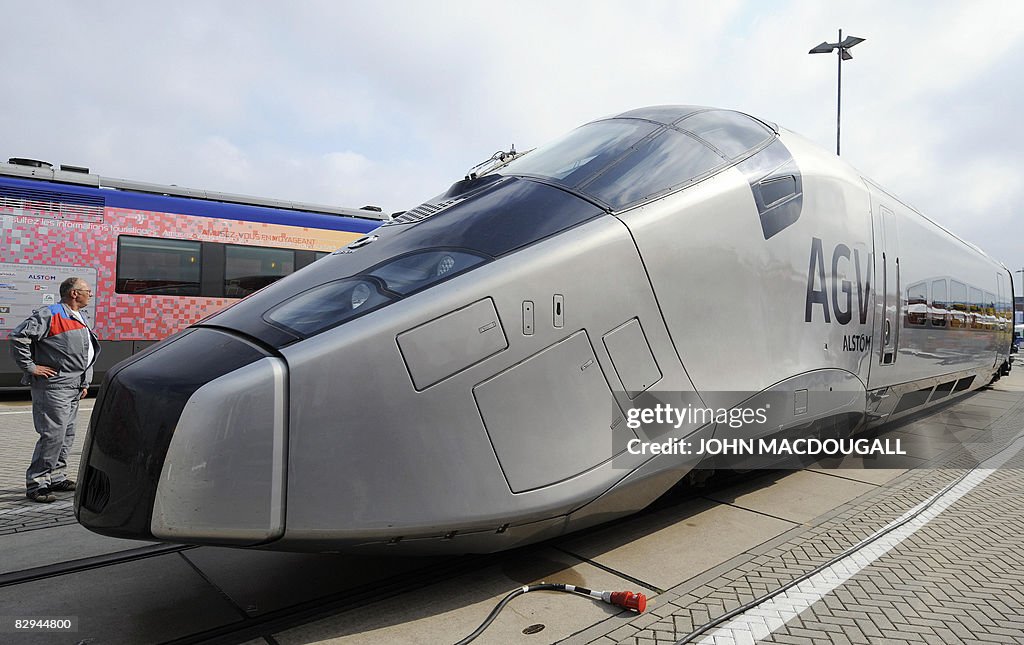 A worker (L) inspects the front carriage