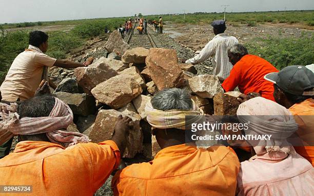 Western Railways' labourers restore the damaged railway line between Viramgam-Surendranagar section some 120 kms from Ahmedabad on September 22,...