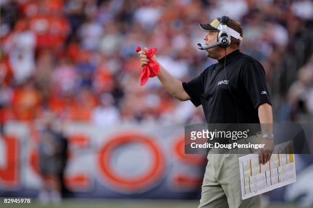 Head coach Sean Payton of the New Orleans Saints prepares to throw the red flag as he leads his team against the Denver Broncos during NFL action at...