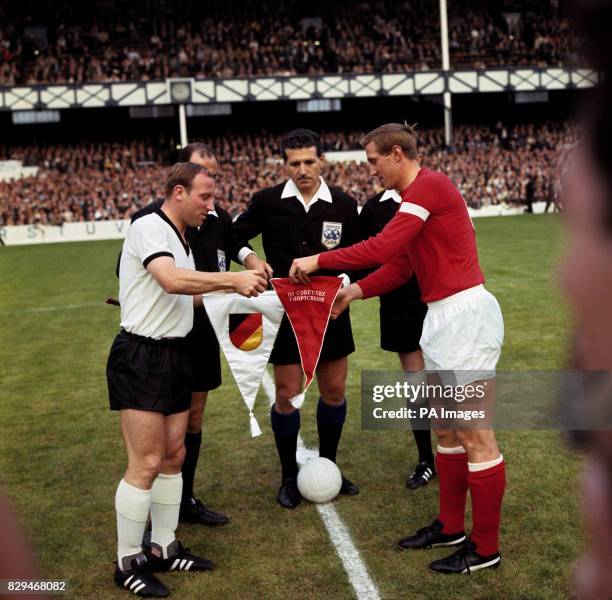 The two captains, West Germany's Uwe Seeler and USSR's Albert Shesterniev , exchange pennants before the match under the watchful eye of referee...